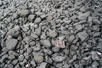 Char-coal. Pattern, heap. Pile of Bituminous Coal cinder. Stone coal Industry, business. Black coal mine close-up with soft focus. Anthracite coal bar