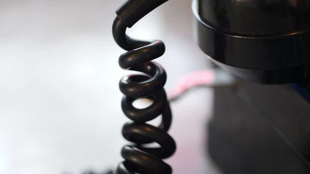 Close up of rotary phone coiled cord