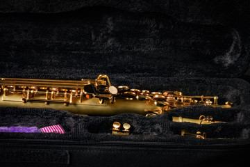 soprano saxophone in a case on a black background