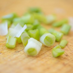 Cut green onion on the brown wooden board
