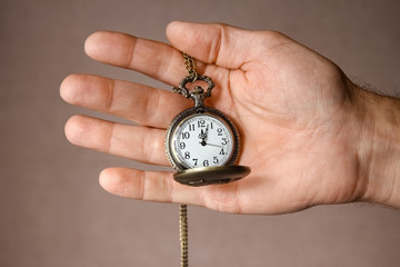 a pocket watch in the hands of a man