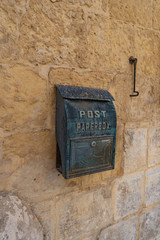Closeup photo of a Vintage postbox on old stone wall