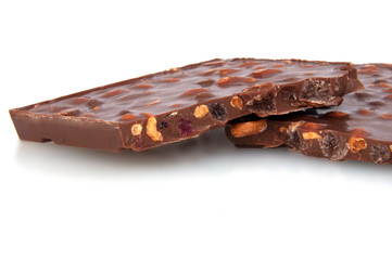 milk chocolate with nuts and berries brocken isolated on the white