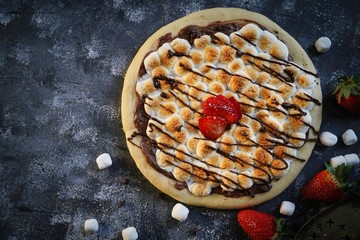 Homemade s'mores desser tpizzatopped with toasted marshmallows and chocolate drizzle