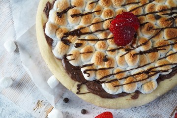 Homemade s'mores desser tpizzatopped with toasted marshmallows and chocolate drizzle