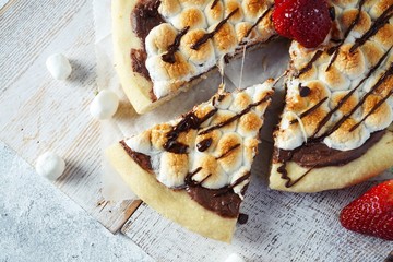 Homemade s'mores desser tpizzatopped with toasted marshmallows and chocolate drizzle