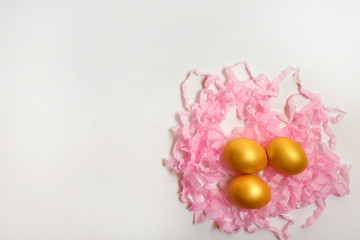 Golden quail eggs on a serpentine on a white background, free space for text or advertising