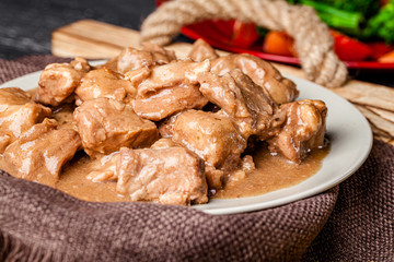 Modern kitchen. Pork meat cooked using sous vide technology in vacuum. Meat gravy in a white plate. board background image, copy space text