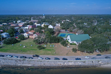 Fototapeta na wymiar Aerial view of Southport North Carolina water front. Cars line the road along the Cape Fear River. Over the water looking back at the town.