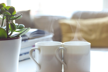Relaxing sofa area with coffee table and hot drink in modern home interior
