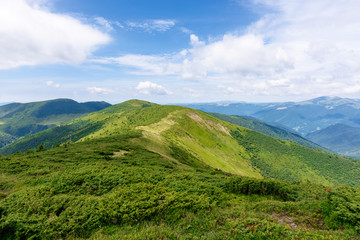 mountain landscape. hiking and tourism concept. rolling hills and distant ridges. green grassy slopes. sunny weather with clouds in summer