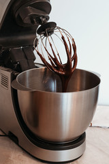 Fototapeta premium Cooking chocolate cream cupcakes. Confectioner cooks in kitchen.