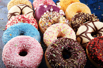 assorted donuts with chocolate frosted, pink glazed and sprinkles donuts