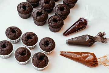 Cooking chocolate cream cupcakes. Confectioner cooks in kitchen.