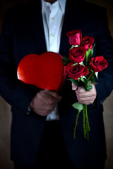 Man Holding Red Roses and Heart Shaped Box of Candy