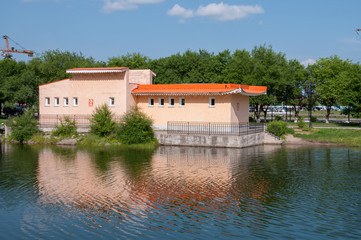 Naklejka na ściany i meble Russia, Blagoveshchensk, July 2019: orange building on a pond in friendship Park in Blagoveshchensk in summer