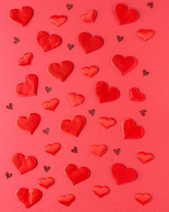 Valentines day composition - decorative hearts on red background. Greeting card. Flat lay, top view.