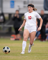 Young athletic girl playing in a soccer match