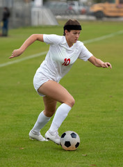 Obraz premium Young athletic girl playing in a soccer match