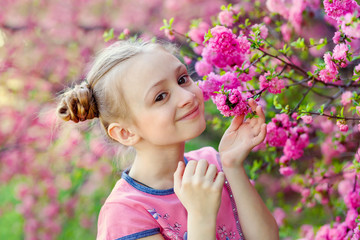 Aromatic blossom concept. Little girl-child tourist posing near sakura. Child on pink flowers of sakura tree background. Girl enjoying cherry blossom or sakura. Cute child enjoy warm spring day.