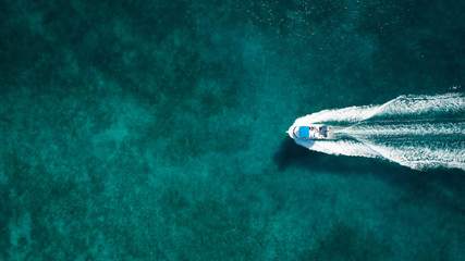 Aerial photography of a boat in the caribbean sea - obrazy, fototapety, plakaty