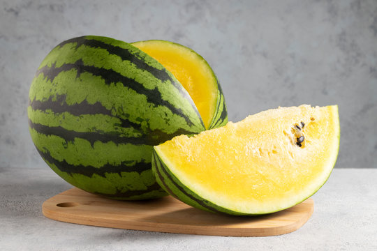 Sliced yellow watermelon on a wooden cutting board on a table