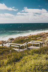 Fototapeta na wymiar view of Cottesloe beach near Perth with thick vegetations and staircases leading to the sandy shore