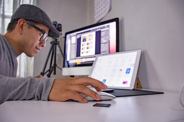 A Young man is working with digital devices at home	