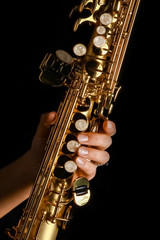 Obraz premium soprano saxophone in hands on a black background
