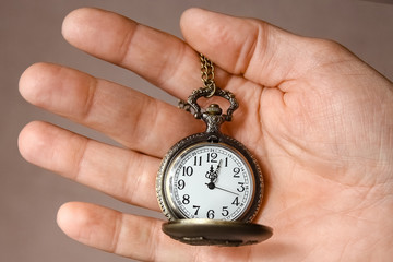 a pocket watch in the hands of a man