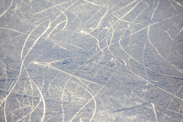 bright traces of ice skating on an ice rink. background and texture