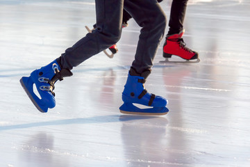 different people are actively skating on an ice rink