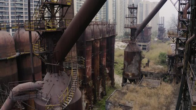 Slow pivot in between metal structures of abandoned steel plant, Guangzhou, China. Aerial shot