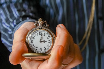 a pocket watch in the hands of a man