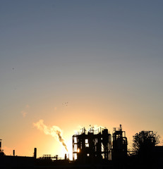 Silhouette of factory at sunset