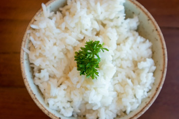 Small bowl of white rice with vegetable decorated on top.