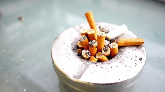 burned cigarette in ashtray on the table.