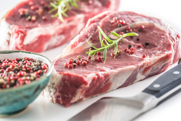 Beef Rib Eye steak with pepper and rosemary isolated on white background