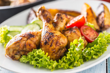 Roasted chicken legs with lettuce salad and tomatoes