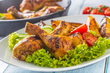 Roasted chicken legs with lettuce salad and tomatoes