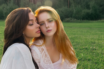 Beautiful gay couple sharing time together and having fun outdoor. Women friendship. Girls in boho fashion clothes. Happy girlfriends having tender moments. LGBT and relationship concept