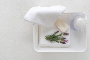 White cotton towels, soap, and lavender flowers on white background, copy space for product display. Aromatherapy, spa concept