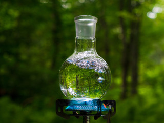 Glass flask with boiling water on a gas burner.