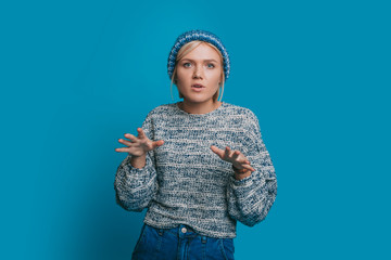 Portrait of a beautiful young blonde woman dressed in blue looking at camera serious storytelling...