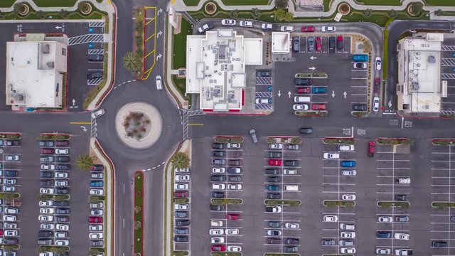 Aerial timelapse of parking lot in a shopping center, drive through, roundabout