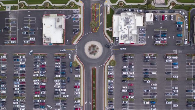 Aerial timelapse of parking lot in a shopping center, drive through, roundabout