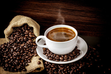 Warm coffee on a wooden plate backgrounds. Vintage backgrounds, Beans backgrounds. Copy space menu.