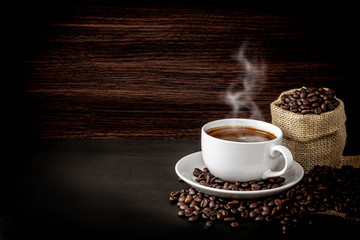 Warm coffee on a wooden plate backgrounds. Vintage backgrounds, Beans backgrounds. Copy space menu.