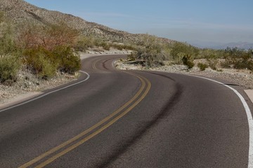 A paved road curves through the desert