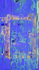 background of brightly painted metal garage wall in blue, green and orange colors with scratches and rust